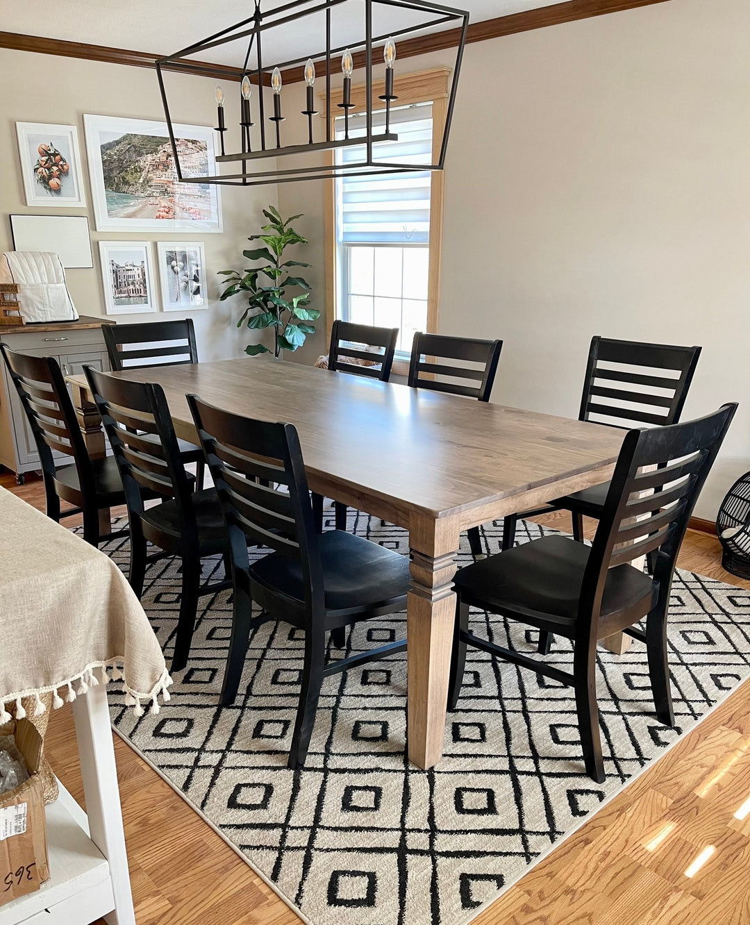 Grey stained dining table with black ladder-back chairs