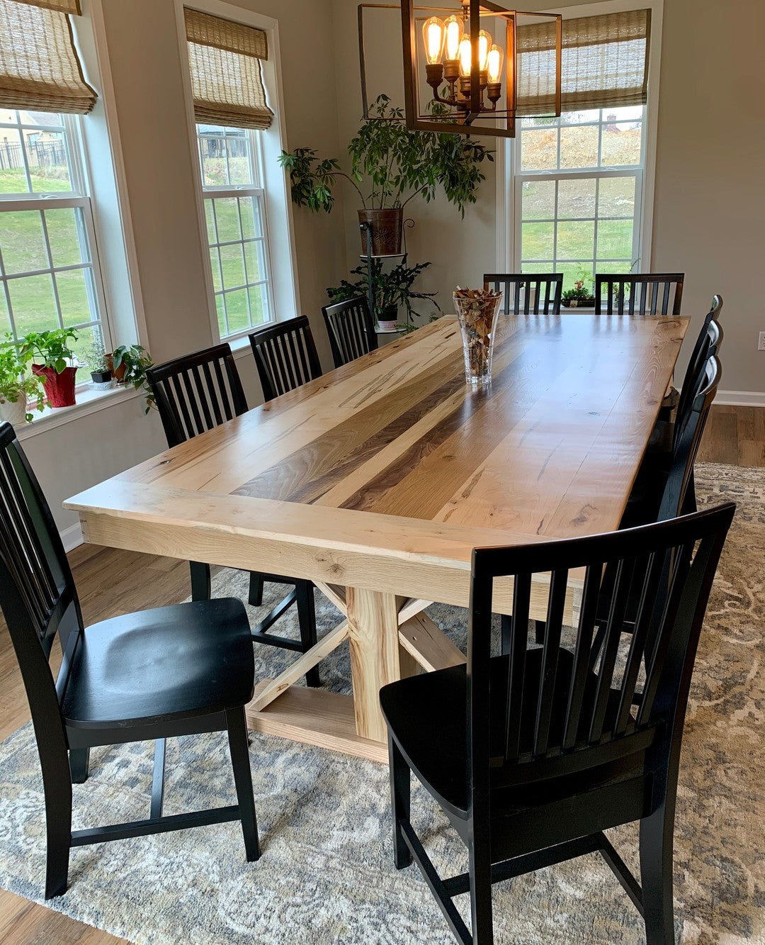 Natural oak trestle dining table with black chairs